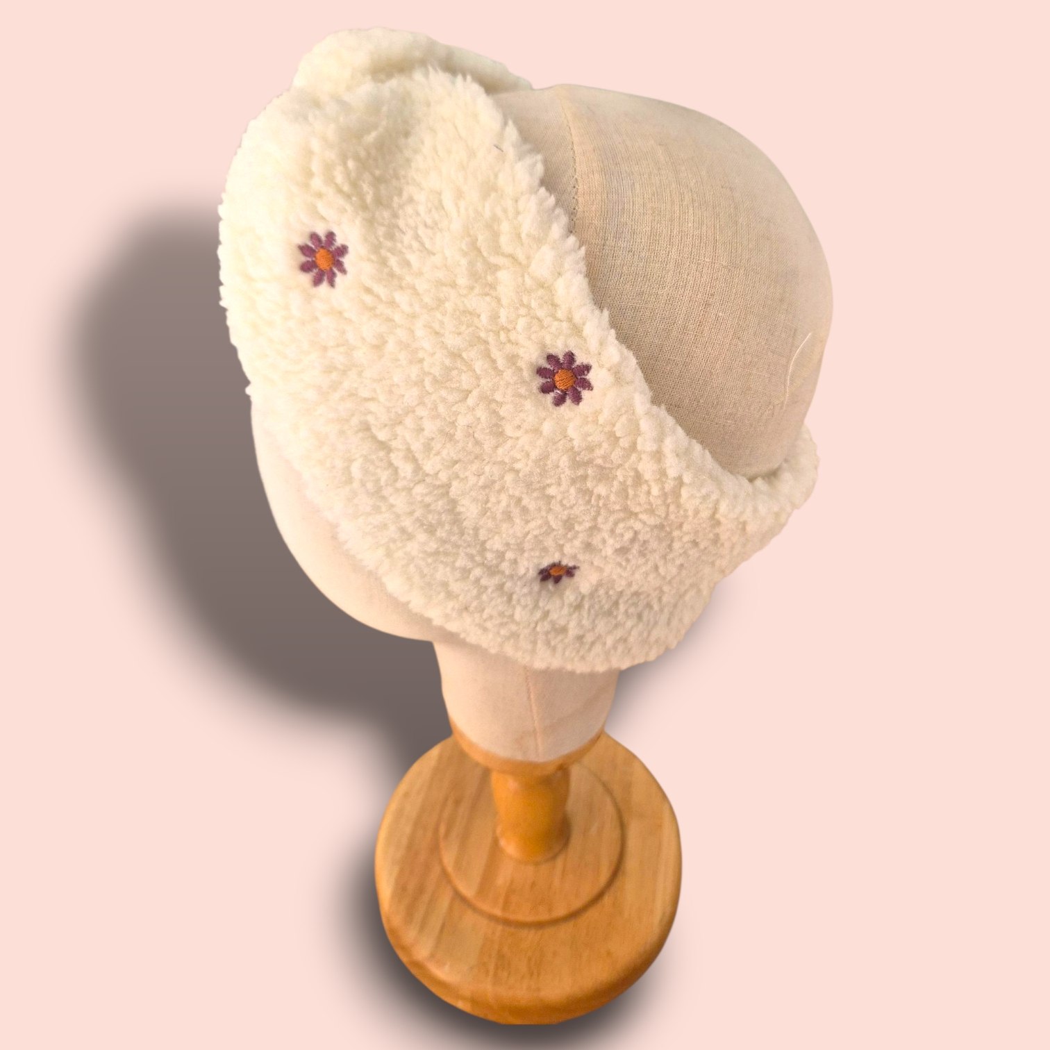 Bandeau en sherpa écru ultra-doux avec pâquerettes brodées, chaud et confortable. L’accessoire d’hiver idéal pour garder vos oreilles au chaud avec style. Un bandeau confortable et élégant, fabriqué à la main sur l’Île d’Oléron.
