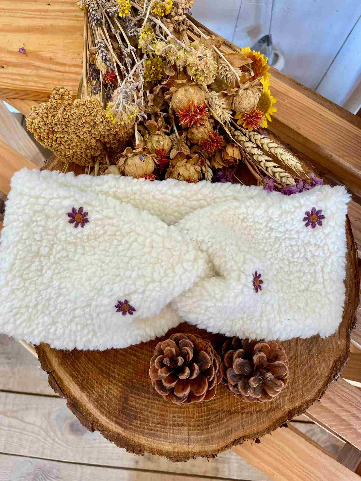 Bandeau en sherpa écru ultra-doux avec pâquerettes brodées, chaud et confortable. L’accessoire d’hiver idéal pour garder vos oreilles au chaud avec style. Un bandeau confortable et élégant, fabriqué à la main sur l’Île d’Oléron.