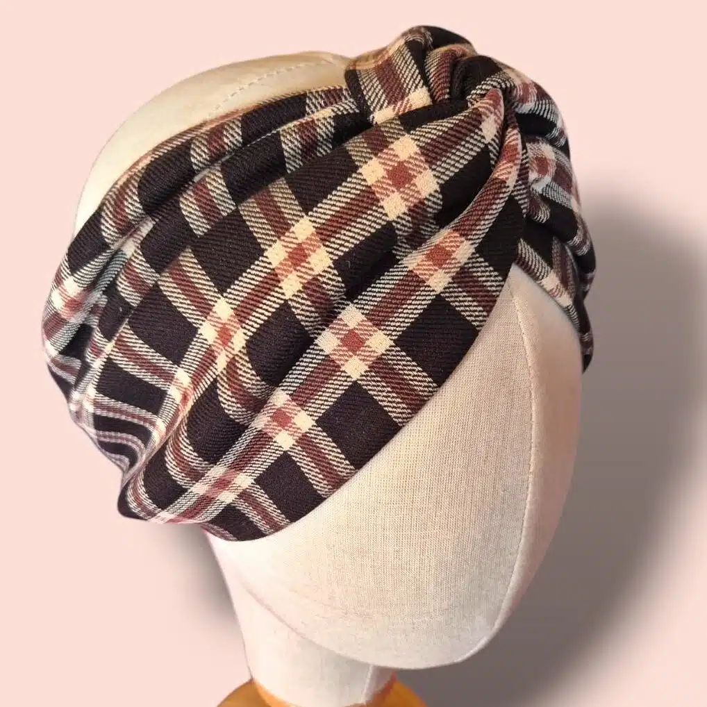 Bandeau turban Viviane à carreaux beige, marron et noir. Un bandeau croisé confortable, chaud et élégant, fabriqué à la main sur l’Île d’Oléron. Parfait pour sublimer toutes vos tenues.